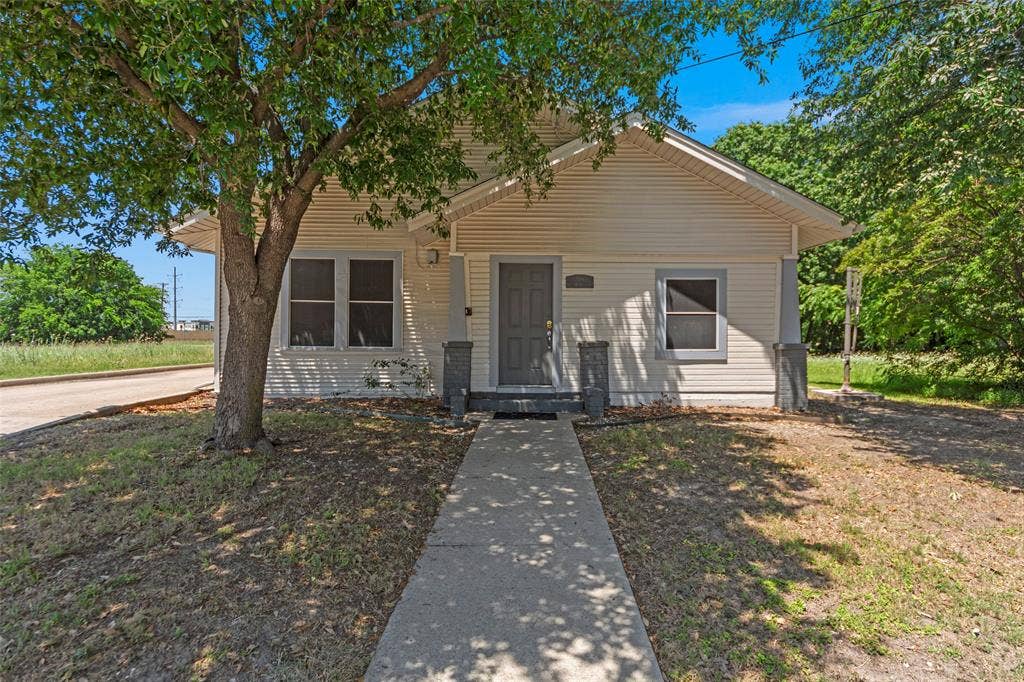 508 W Main Street, Allen, TX 75013 White horizontal siding exterior with a gabled roofline and an entry door