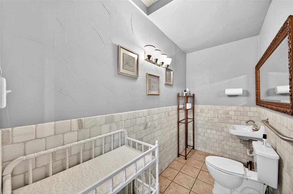 508 W Main Street, Allen, TX 75013 Light gray wall finish with wainscoting, pedestal sink, and tiled flooring