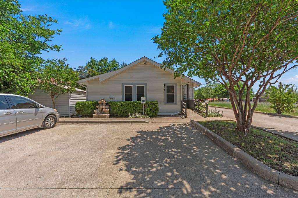 508 W Main Street, Allen, TX 75013 Charming single-story home featuring a gable roof, front-facing windows with dark trim, and a concrete driveway