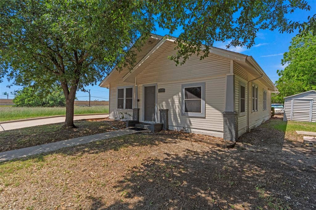 508 W Main Street, Allen, TX 75013 Siding exterior with a covered entry, concrete walkway, mature tree, and a detached storage shed