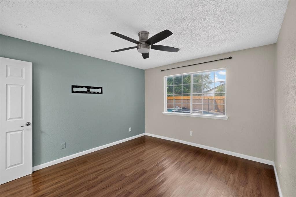 6747 Silver Sage Drive, Fort Worth, TX 76137 Wood-finish flooring, ceiling fan, and a window providing natural illumination