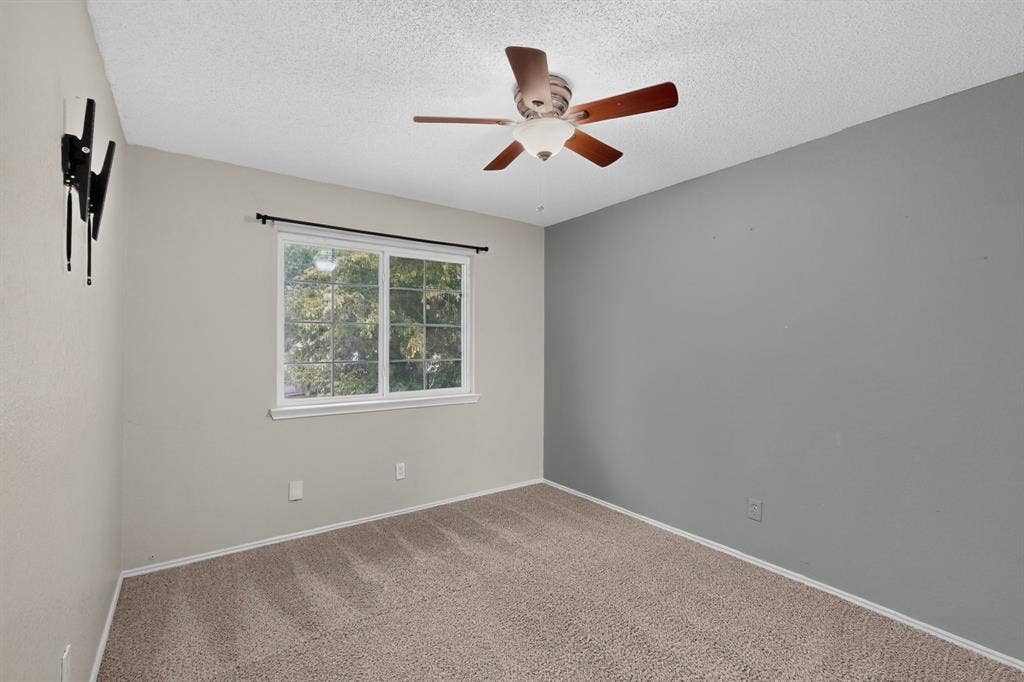 6747 Silver Sage Drive, Fort Worth, TX 76137 Carpeted flooring, ceiling fan with light fixture, window with white trim, and a two-tone painted wall