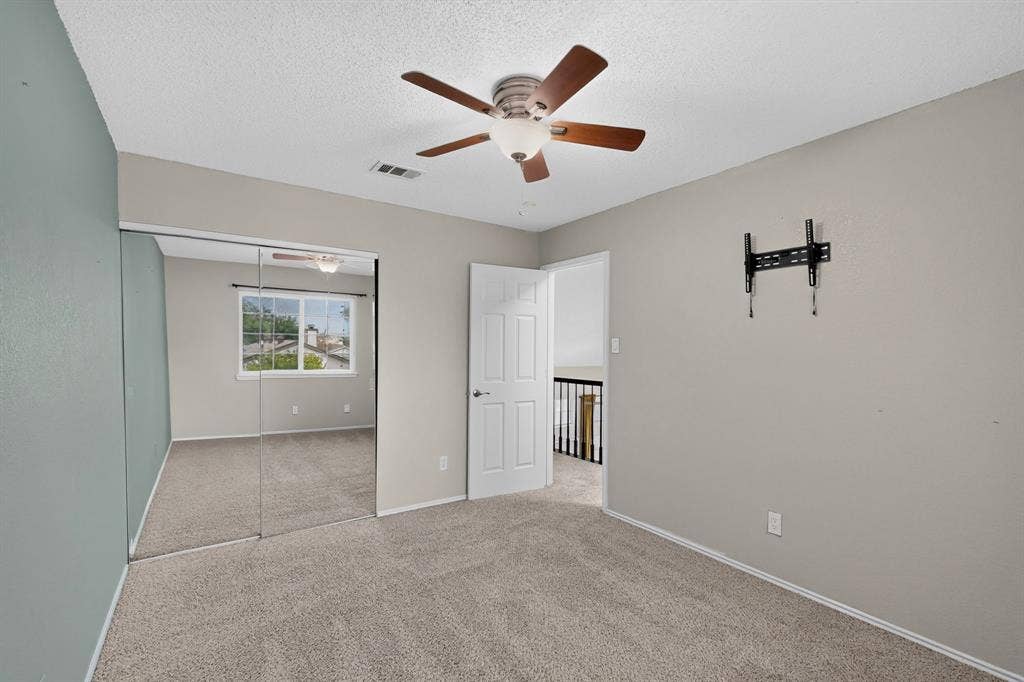 6747 Silver Sage Drive, Fort Worth, TX 76137 Carpeted flooring, mirrored sliding closet doors, ceiling fan with integrated lighting, wall-mounted television bracket