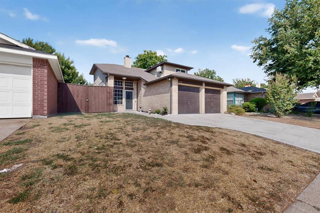 6747 Silver Sage Drive, Fort Worth, TX 76137 Brick and siding exterior, front entry with transom window, concrete driveway, two-car garage, and partial wood fence