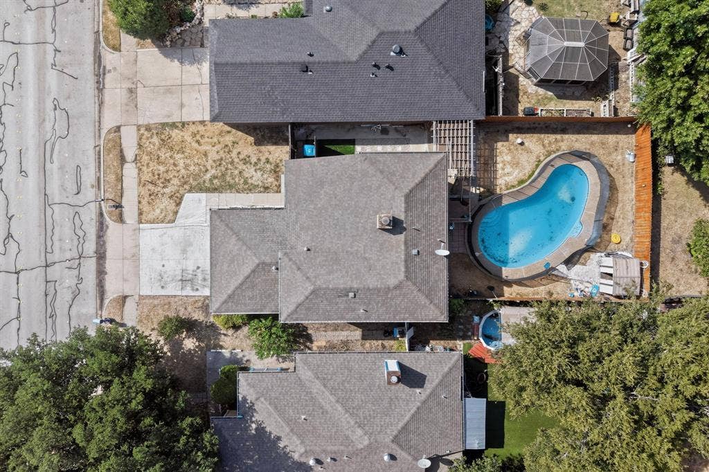 6747 Silver Sage Drive, Fort Worth, TX 76137 Rear yard featuring an in-ground swimming pool, a detached covered patio structure, and a perimeter fence