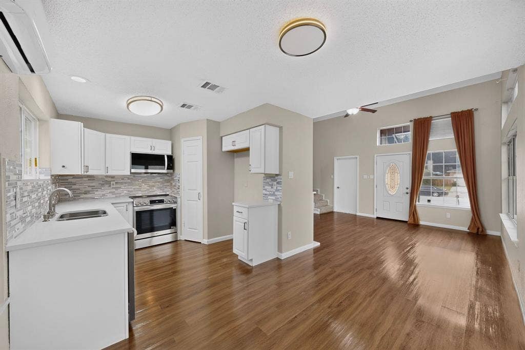 6747 Silver Sage Drive, Fort Worth, TX 76137 Kitchen featuring white cabinetry, stainless steel appliances, and a mosaic tile backsplash