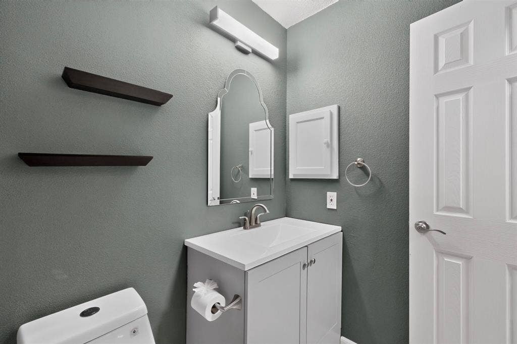 6747 Silver Sage Drive, Fort Worth, TX 76137 White vanity with an integrated sink and brushed nickel faucet, wall-mounted mirror, recessed medicine cabinet, and panel door