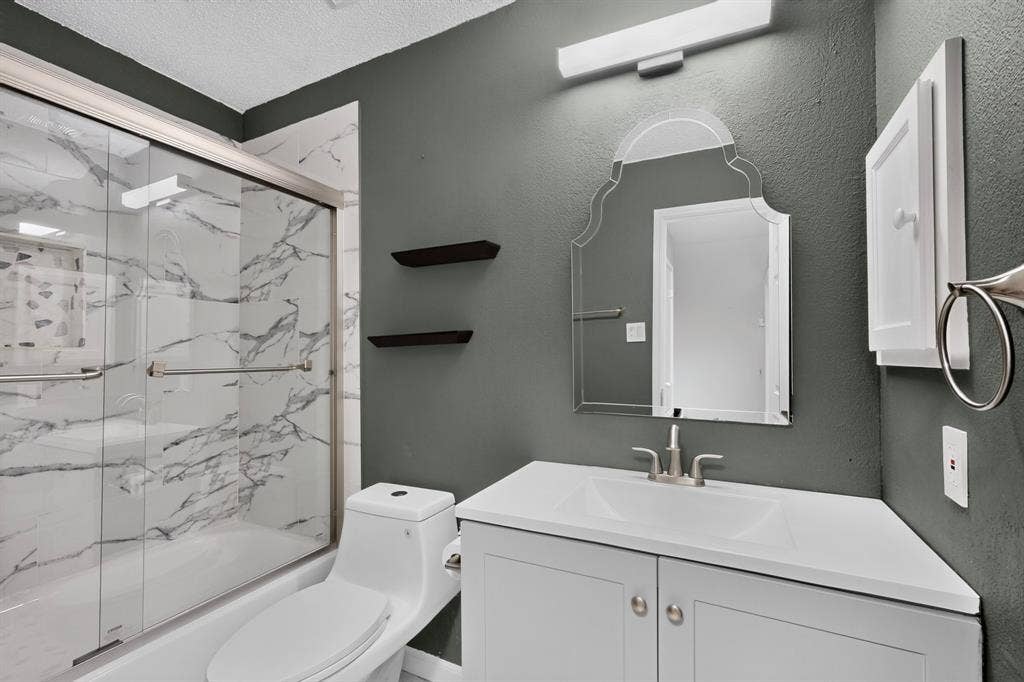 6747 Silver Sage Drive, Fort Worth, TX 76137 Walk-in shower with sliding glass doors and marble-style tile surround