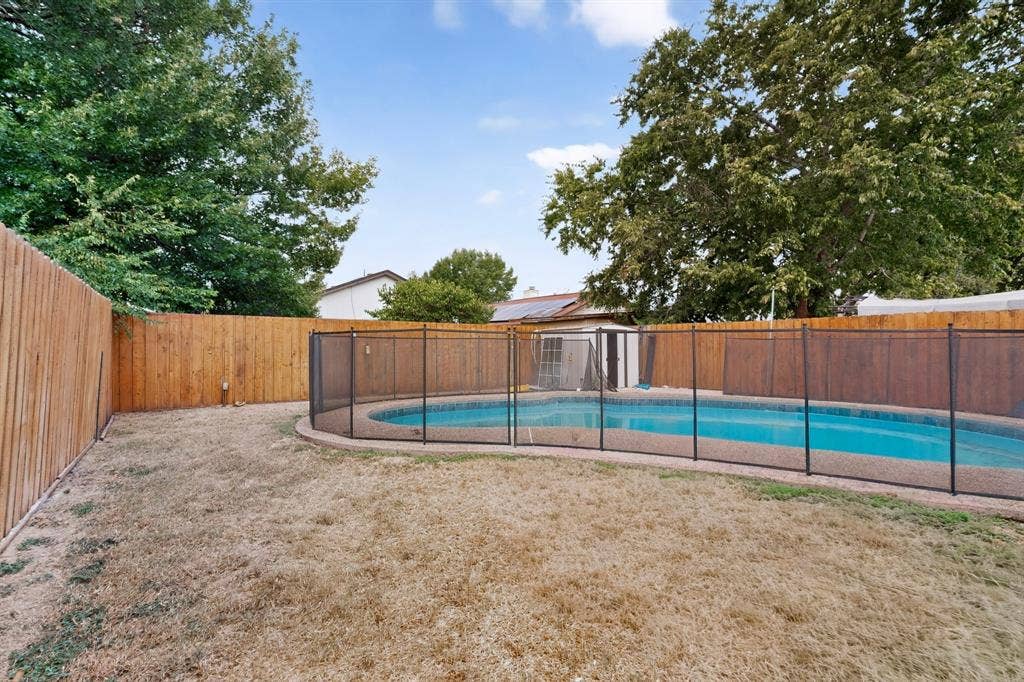 6747 Silver Sage Drive, Fort Worth, TX 76137 In-ground swimming pool with a black mesh safety fence
