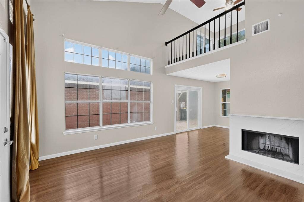 6747 Silver Sage Drive, Fort Worth, TX 76137 Vaulted ceilings, wood-finish flooring, a contemporary fireplace, and a second-story interior balcony