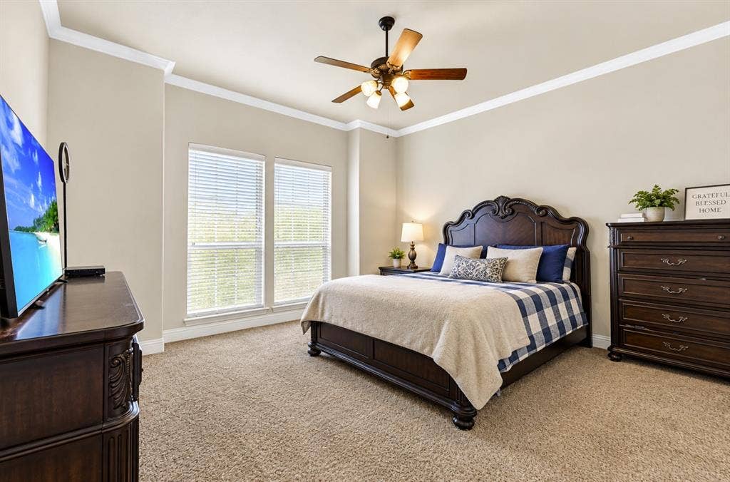 12038 Big Springs Drive, Frisco, TX 75035 Deep tray ceilings and high-set windows give this primary bedroom a wonderfully airy feel while catching the soft daylight. It is the ultimate private haven for sleeping in on lazy Sunday mornings.