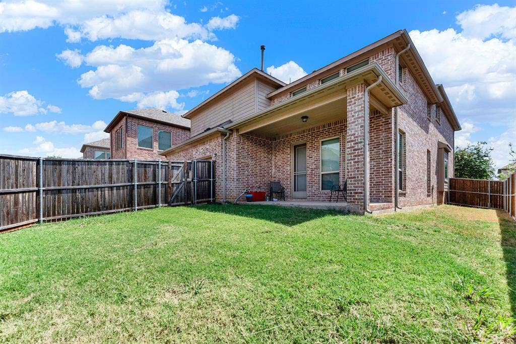 12038 Big Springs Drive, Frisco, TX 75035 Expansive green turf spans the backyard, offering plenty of elbow room along the side elevation. Picture hosting lively weekend lawn games with friends and family with space to spare.