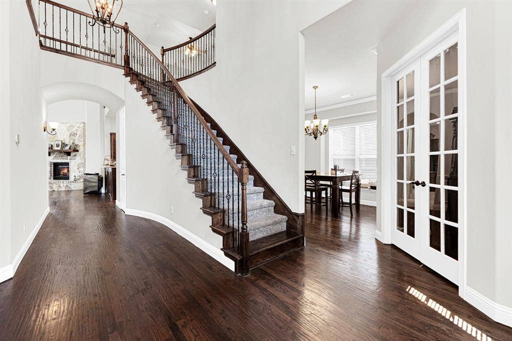 12038 Big Springs Drive, Frisco, TX 75035 The sweeping curved staircase with wrought-iron spindles elegant sweeps upward, anchoring the entry hallway. It sets a warm, inviting backdrop for greeting guests as they arrive for holiday dinner parties.