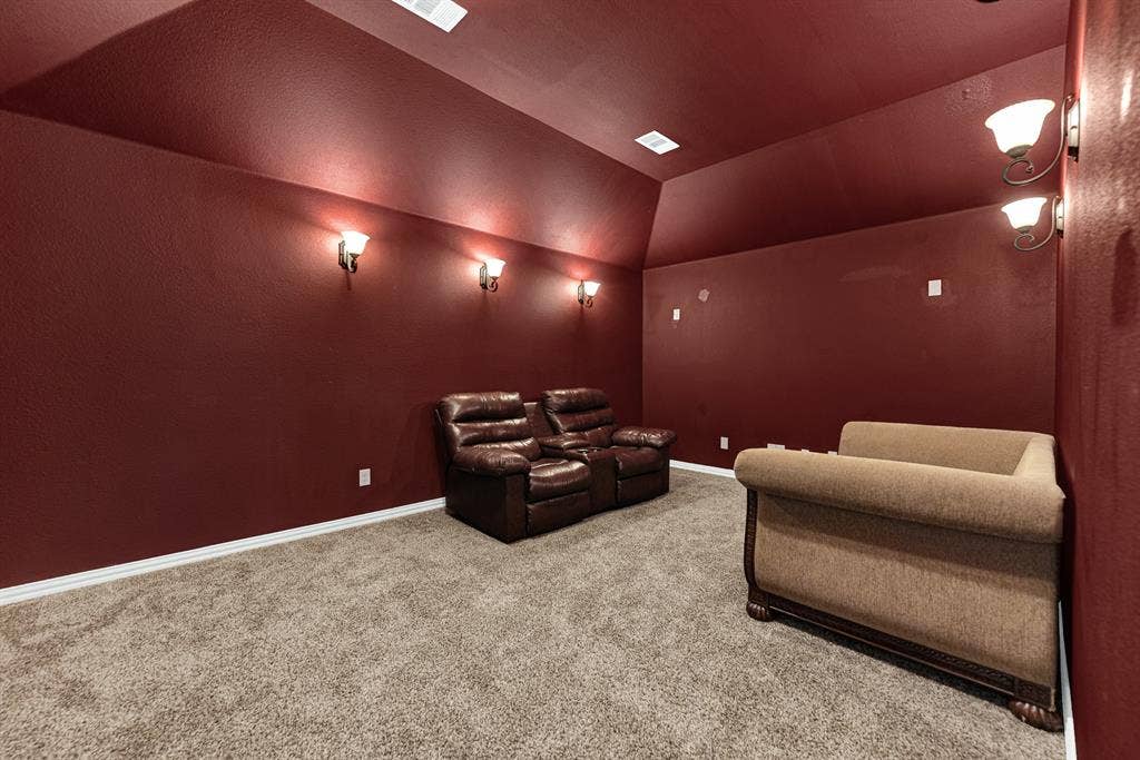 12038 Big Springs Drive, Frisco, TX 75035 Rich crimson walls paired with ambient wall sconces create a true cinematic, cocoon-like atmosphere. Dim the lights and settle in for an authentic, immersive home theater experience on Friday night