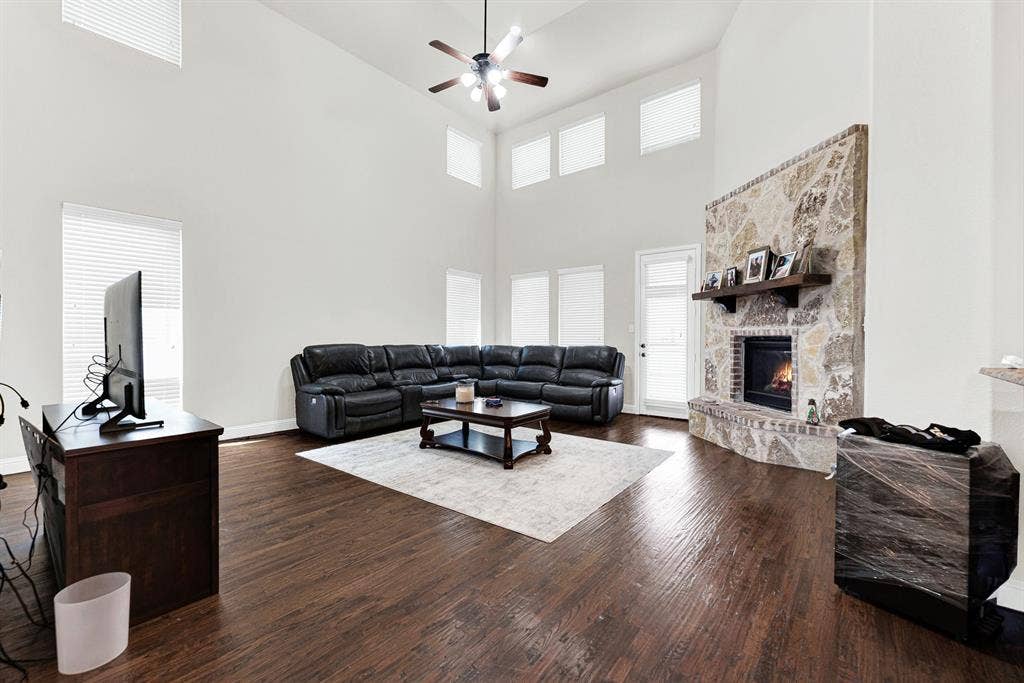 12038 Big Springs Drive, Frisco, TX 75035 The stone fireplace draws your eyes right up toward the soaring double-height ceilings and cascading natural light. Picture gathering around a crackling fire with loved ones on a chilly winter evening.