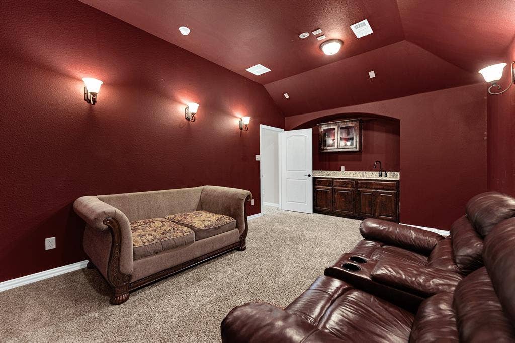 12038 Big Springs Drive, Frisco, TX 75035 A dedicated wet bar alcove featuring dark wood cabinetry and granite counter space fits neatly into the theater room layout. Grab fresh popcorn and chilled beverages without missing a single frame of the feature film