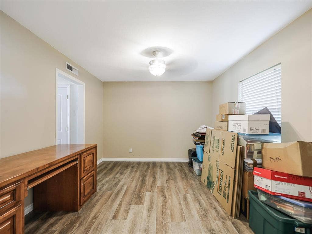 Wood-finish flooring, neutral wall tones, recessed lighting, and a built-in wood desk