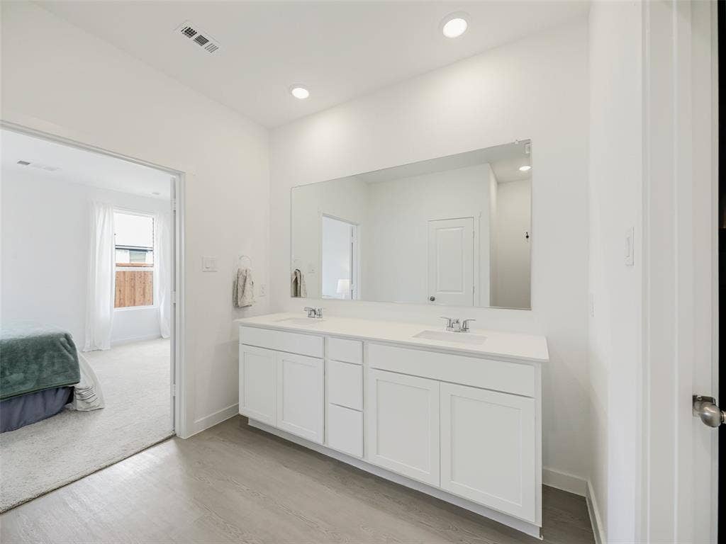 2517 Greenbelt Road, Celina, TX 75009 Double vanity with white cabinetry, integrated sinks, white countertop, and a large wall-mounted mirror