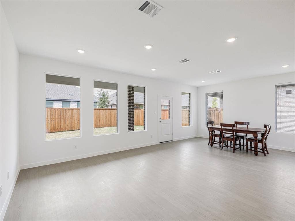 2517 Greenbelt Road, Celina, TX 75009 Light wood-finish flooring, recessed lighting, multiple windows, and a rear exterior door