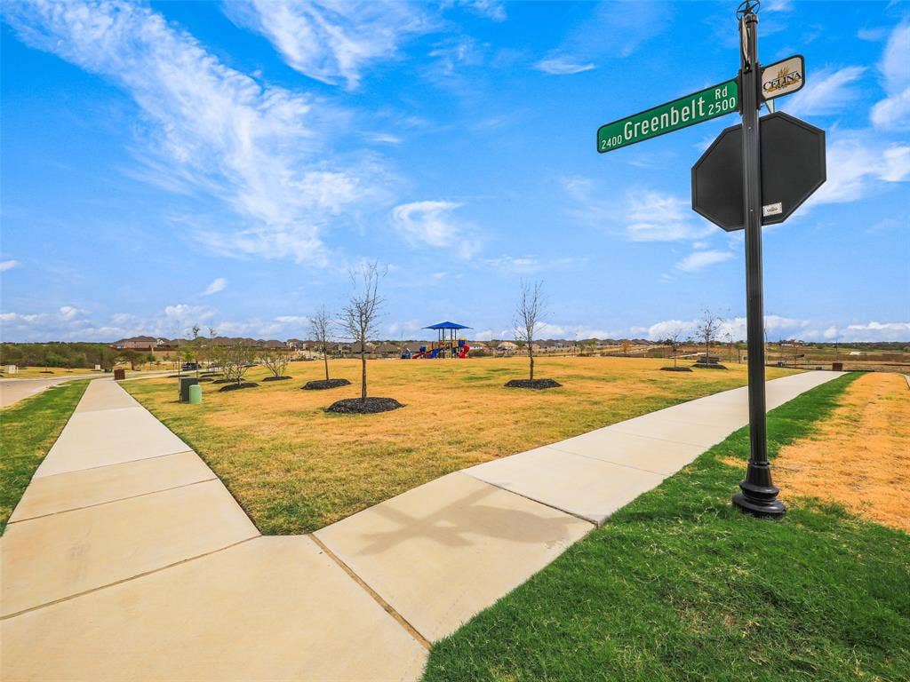 2517 Greenbelt Road, Celina, TX 75009 Expansive green space featuring a concrete pathway and young trees