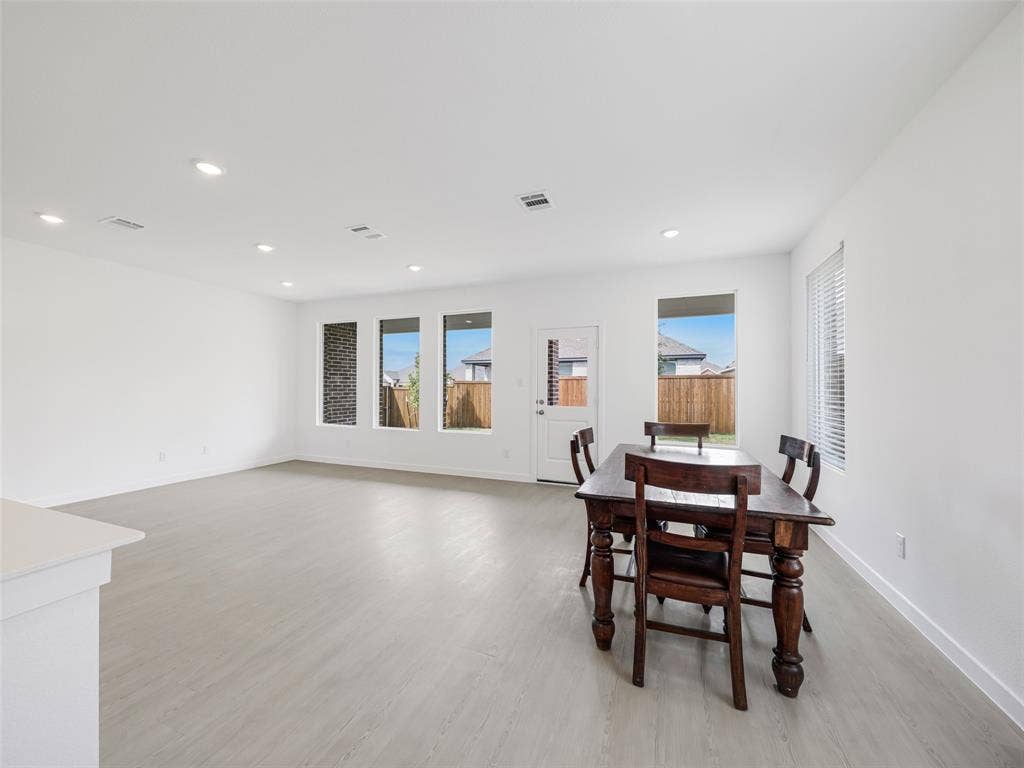 2517 Greenbelt Road, Celina, TX 75009 Recessed lighting, light wood-finish flooring, white walls, multiple windows, and a white door with a window