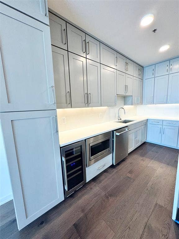 6911 Cowboys Way, #803, Frisco, TX 75034 Kitchen with sink, gray cabinetry, dark hardwood / wood-style flooring, stainless steel appliances, and beverage cooler