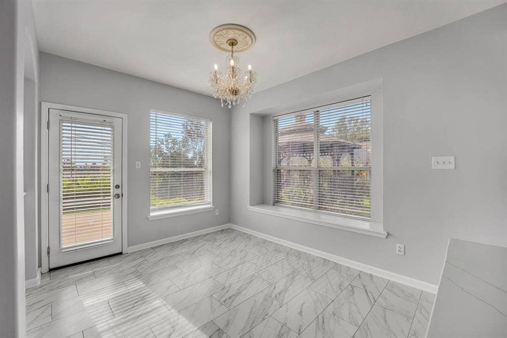 Recessed window seat, glass-paneled door, and large windows with horizontal blinds