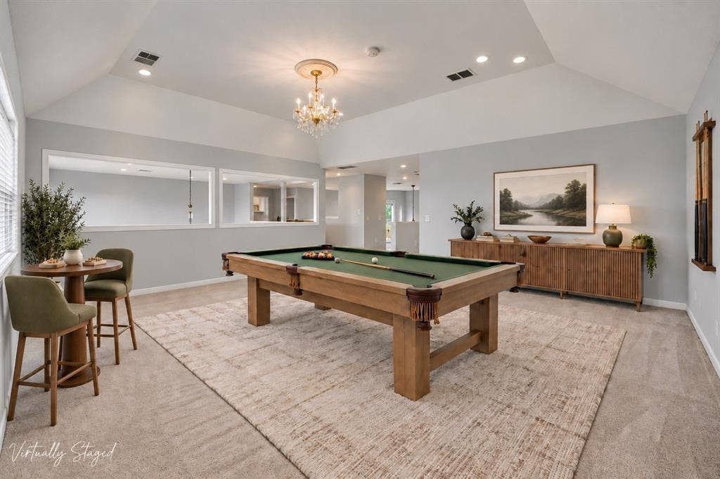 Vaulted ceiling with a central chandelier and recessed lighting