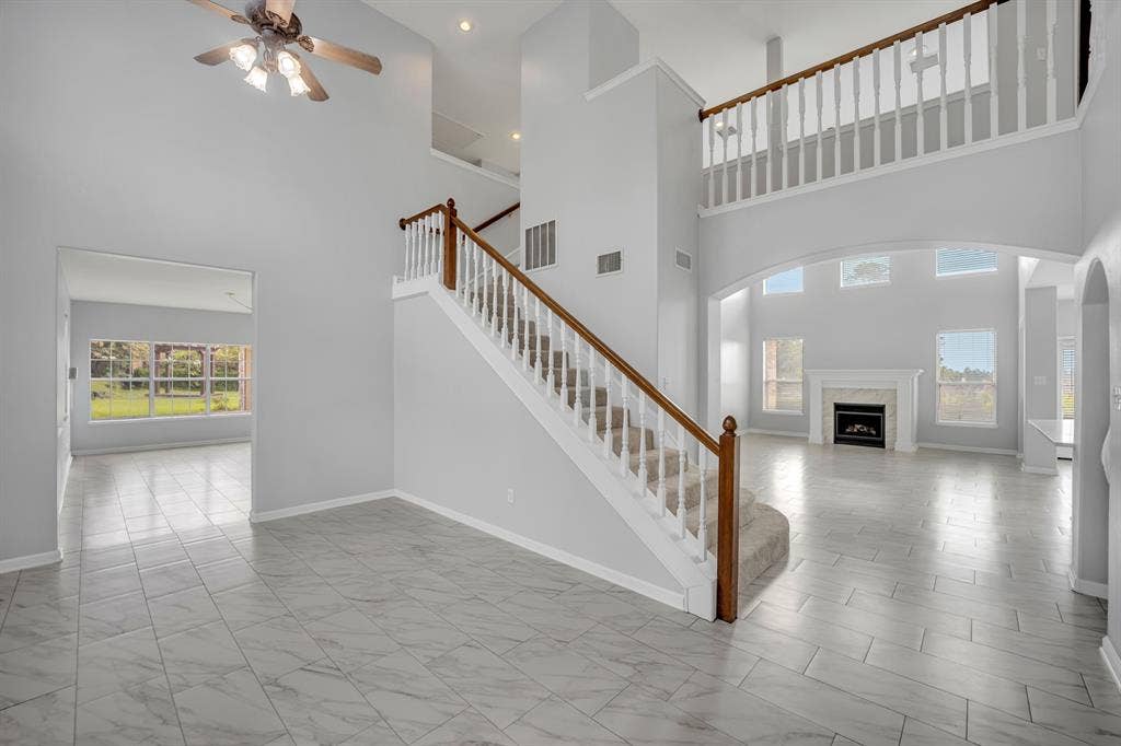 Two-story foyer with a wood-finish staircase and white balusters