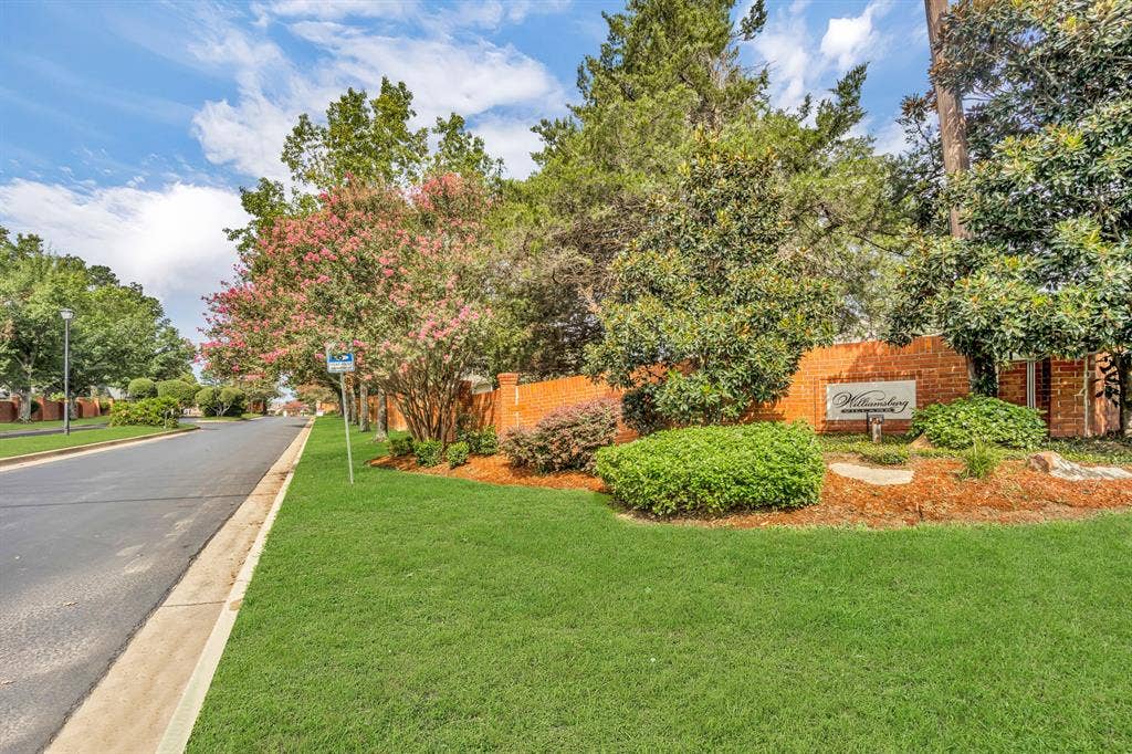 Manicured landscaping with mature trees and a brick wall