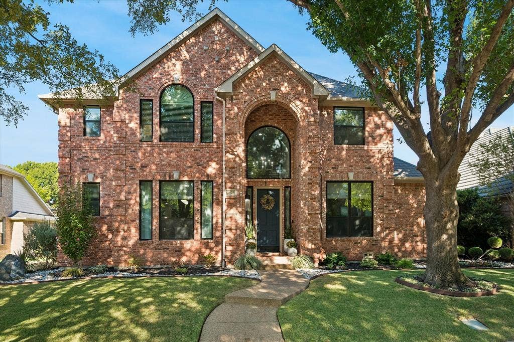 7525 Cedar Elm Drive, Irving, TX 75063 Brick facade with arched entryway and symmetrical landscaping