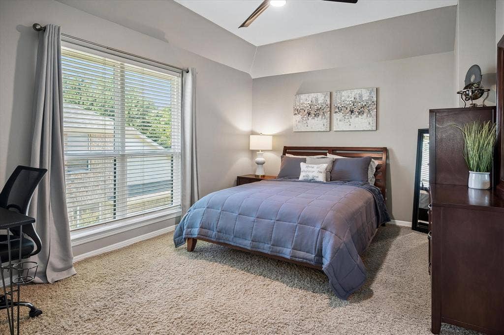 7525 Cedar Elm Drive, Irving, TX 75063 Neutral wall paint, carpeted flooring, large window with blinds, ceiling fan, and tray ceiling