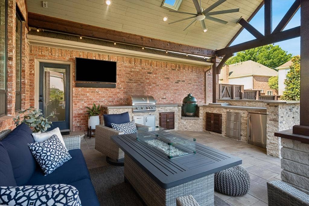 7525 Cedar Elm Drive, Irving, TX 75063 Covered patio featuring a ceiling fan, skylight, built-in outdoor kitchen with stainless steel appliances, and a paver patio surface
