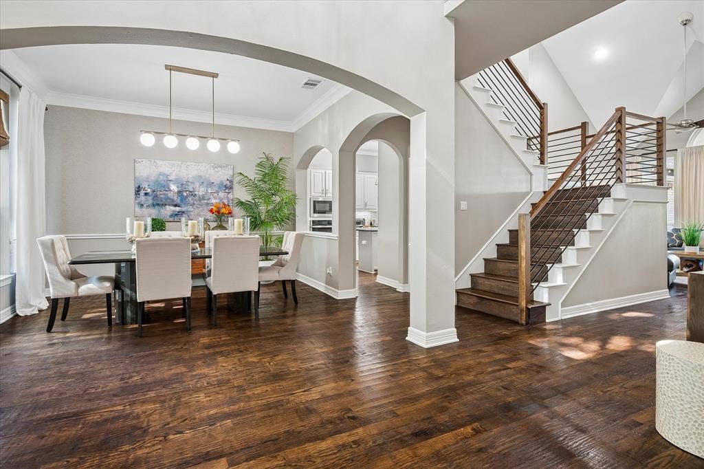 7525 Cedar Elm Drive, Irving, TX 75063 Hardwood flooring throughout, arched doorways, a contemporary staircase with wood and metal railing, recessed lighting, and crown molding
