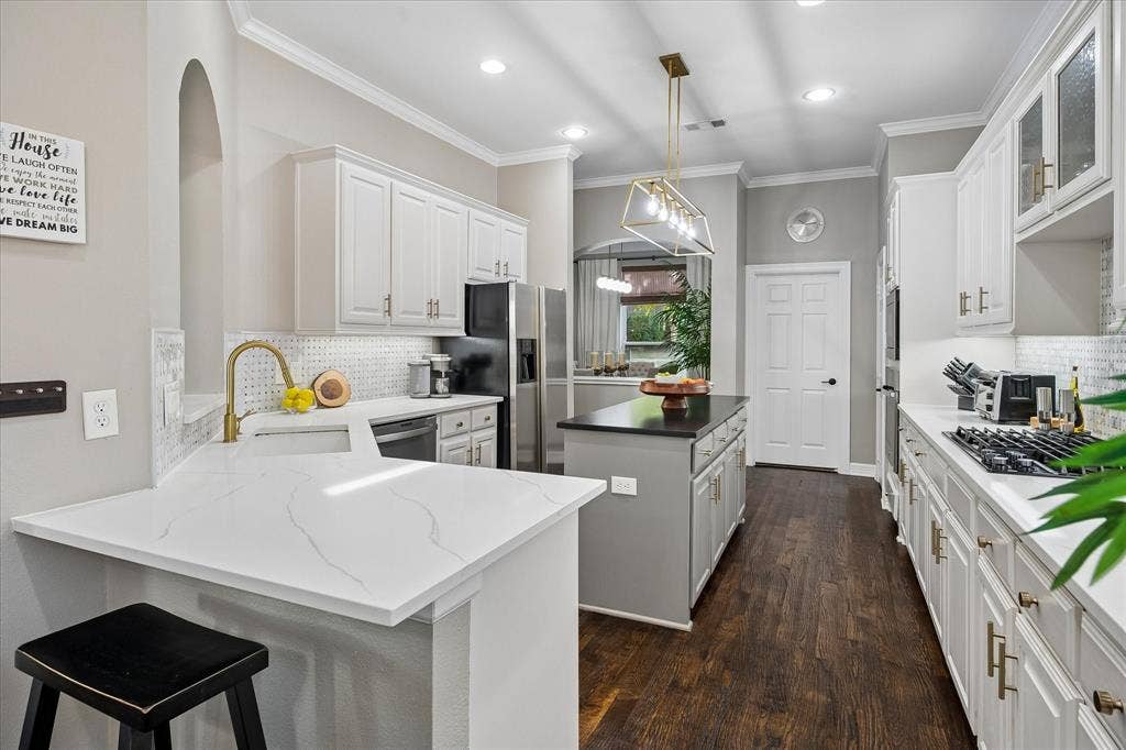 7525 Cedar Elm Drive, Irving, TX 75063 Kitchen featuring white cabinetry, light-toned countertops, a central island, wood-finish flooring, and recessed lighting