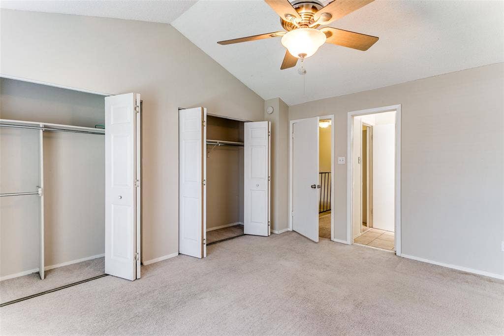 238 Samuel Boulevard, #1T, Coppell, TX 75019 Vaulted ceiling, ceiling fan with integrated lighting, two bi-fold door closets, neutral wall paint, and carpet flooring