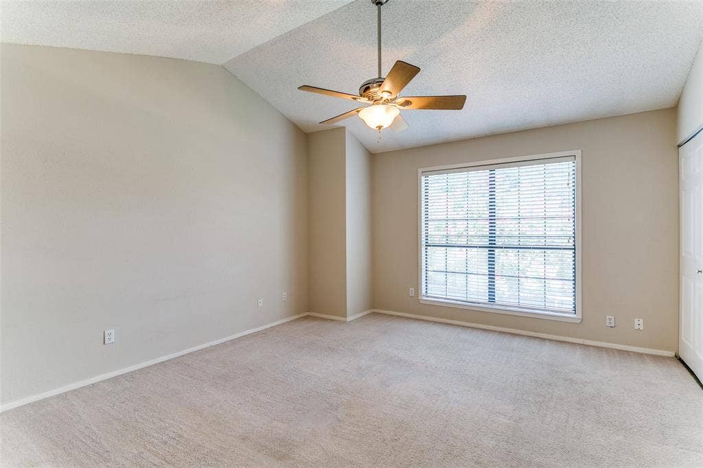 238 Samuel Boulevard, #1T, Coppell, TX 75019 Vaulted ceiling, ceiling fan with integrated lighting, large window with blinds, light-colored carpet flooring, neutral paint palette
