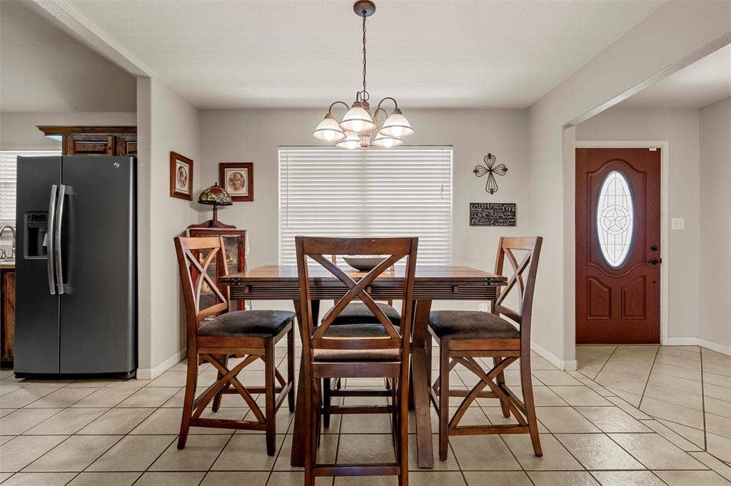 Tile flooring with decorative inlays, recessed lighting, and a chandelier fixture