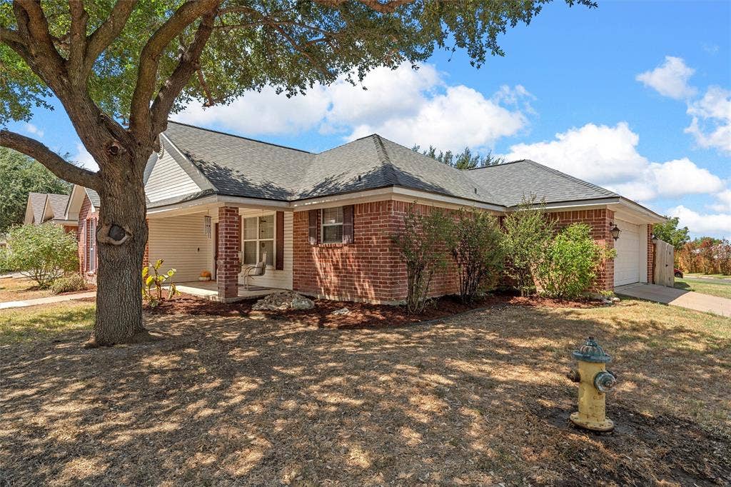 Brick exterior with white siding accents and a covered front porch