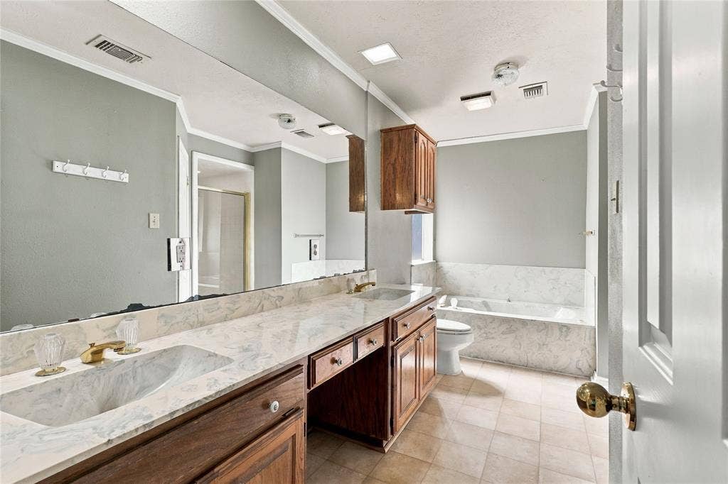 1309 Oxford Lane, Denton, TX 76209 Dual vanity with integrated sinks and gold-tone fixtures