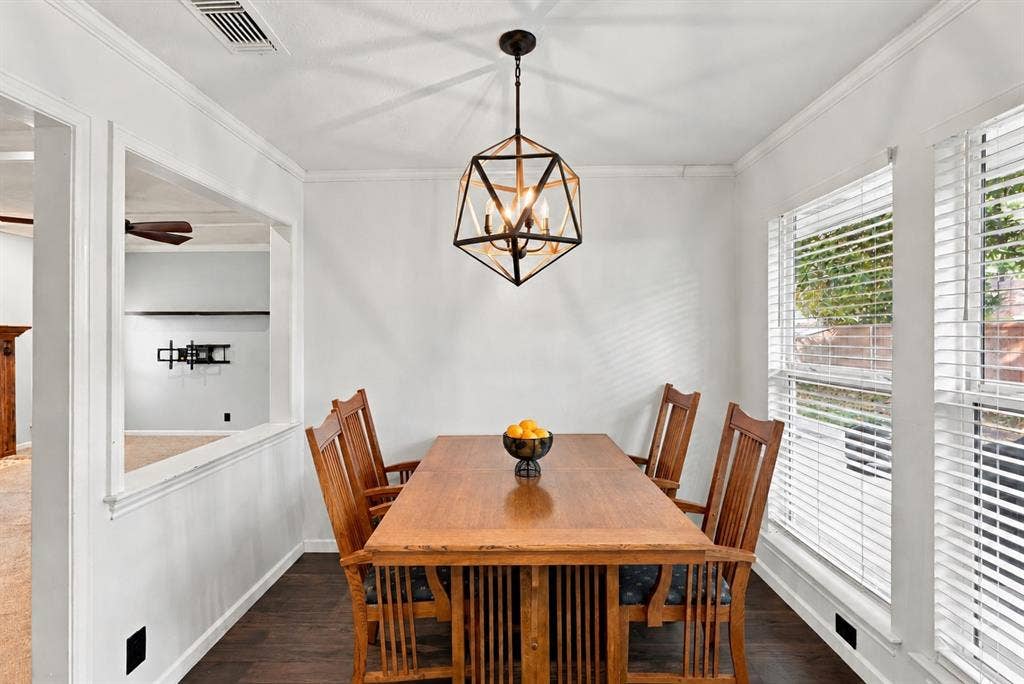 1309 Oxford Lane, Denton, TX 76209 Wood-finish flooring, contemporary geometric chandelier, white trim details, and bright windows with blinds
