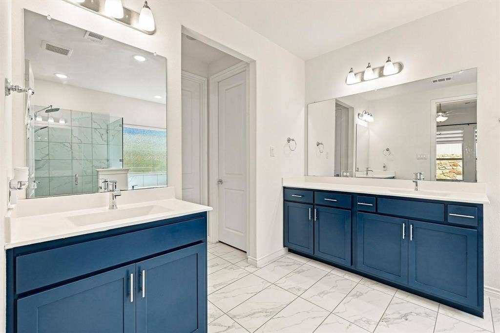 2812 Dunbar Drive, Northlake, TX 76247 Dual vanities featuring blue cabinetry and white countertops