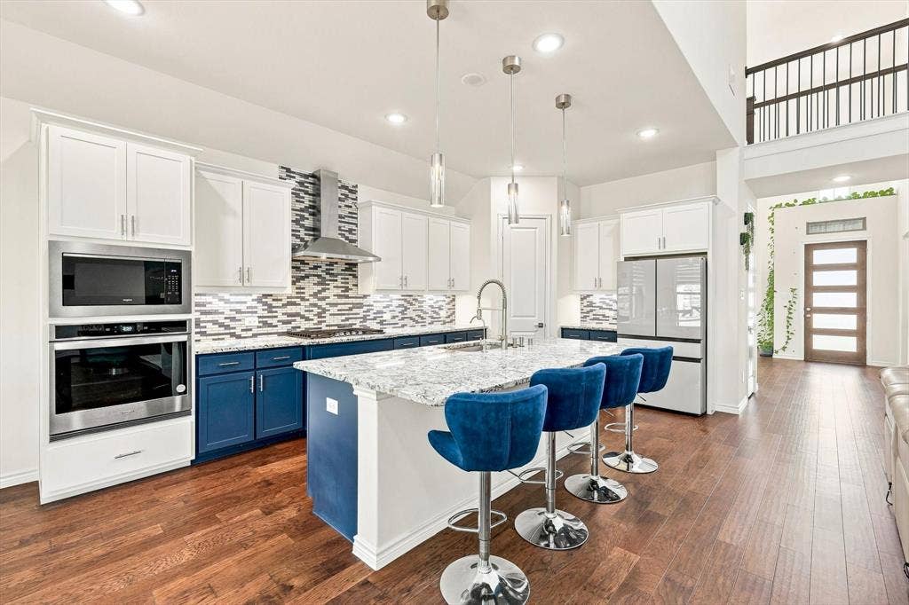 2812 Dunbar Drive, Northlake, TX 76247 Gourmet kitchen with stainless steel appliances, two-tone cabinetry, a mosaic tile backsplash, and a large central island
