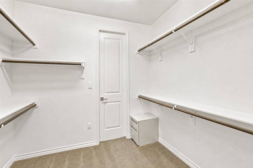 2812 Dunbar Drive, Northlake, TX 76247 Walk-in closet with ample shelving, multiple hanging rods, and carpet flooring