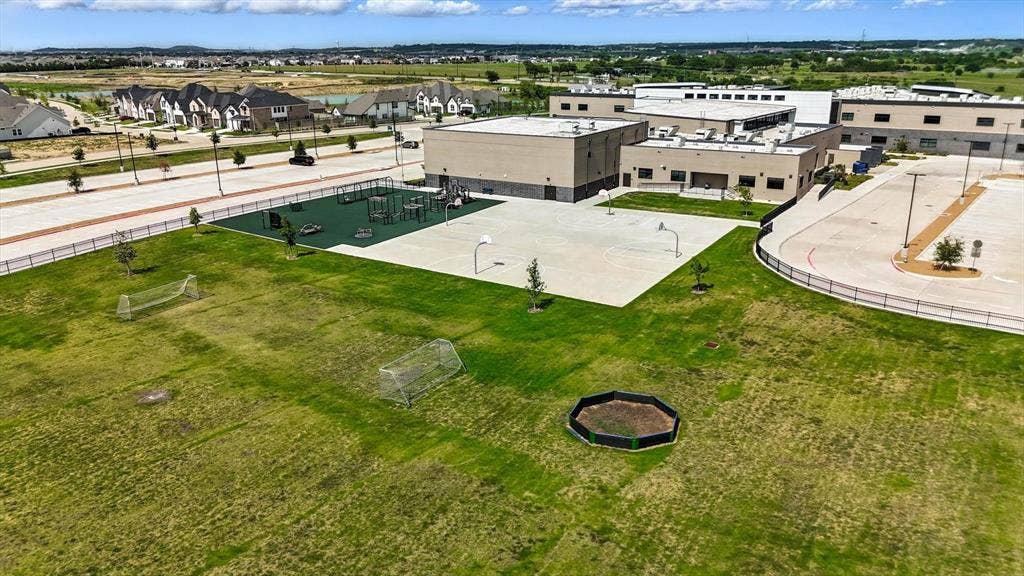 2812 Dunbar Drive, Northlake, TX 76247 Expansive green space featuring two soccer goals, a playground with safety surfacing, and a paved basketball court