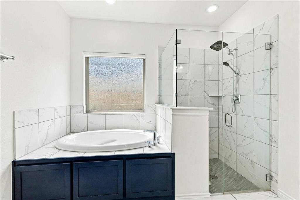 2812 Dunbar Drive, Northlake, TX 76247 Corner soaking tub with dark cabinetry and surrounding tile, alongside a frameless glass shower enclosure with a rain shower head and handheld spray