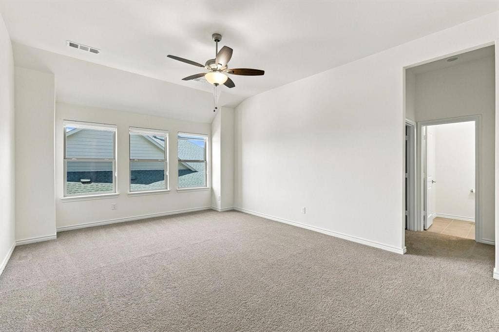 2812 Dunbar Drive, Northlake, TX 76247 Vaulted ceiling, ceiling fan with integrated lighting, three large windows, neutral carpet, and white walls