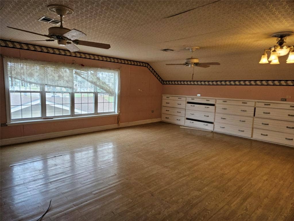 716 Dogwood Street, Robinson, TX 76706 Additional living space featuring ceiling fan, wood finished floors, and vaulted ceiling