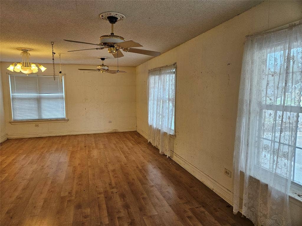 716 Dogwood Street, Robinson, TX 76706 Spare room featuring hardwood / wood-style flooring, a textured ceiling, ceiling fan, and hanging lights