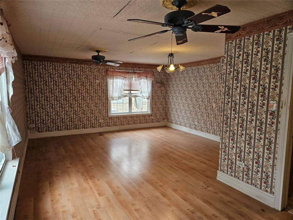 716 Dogwood Street, Robinson, TX 76706 Unfurnished room featuring light wood-style flooring, wallpapered walls, and a ceiling fan